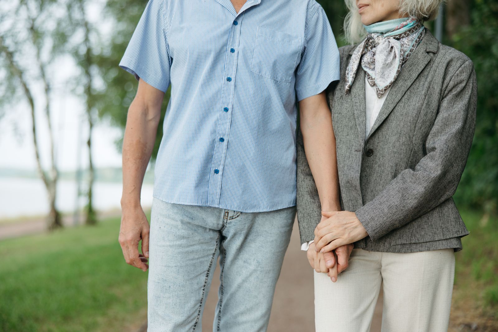 Close view of two older adults walking together and holding hands