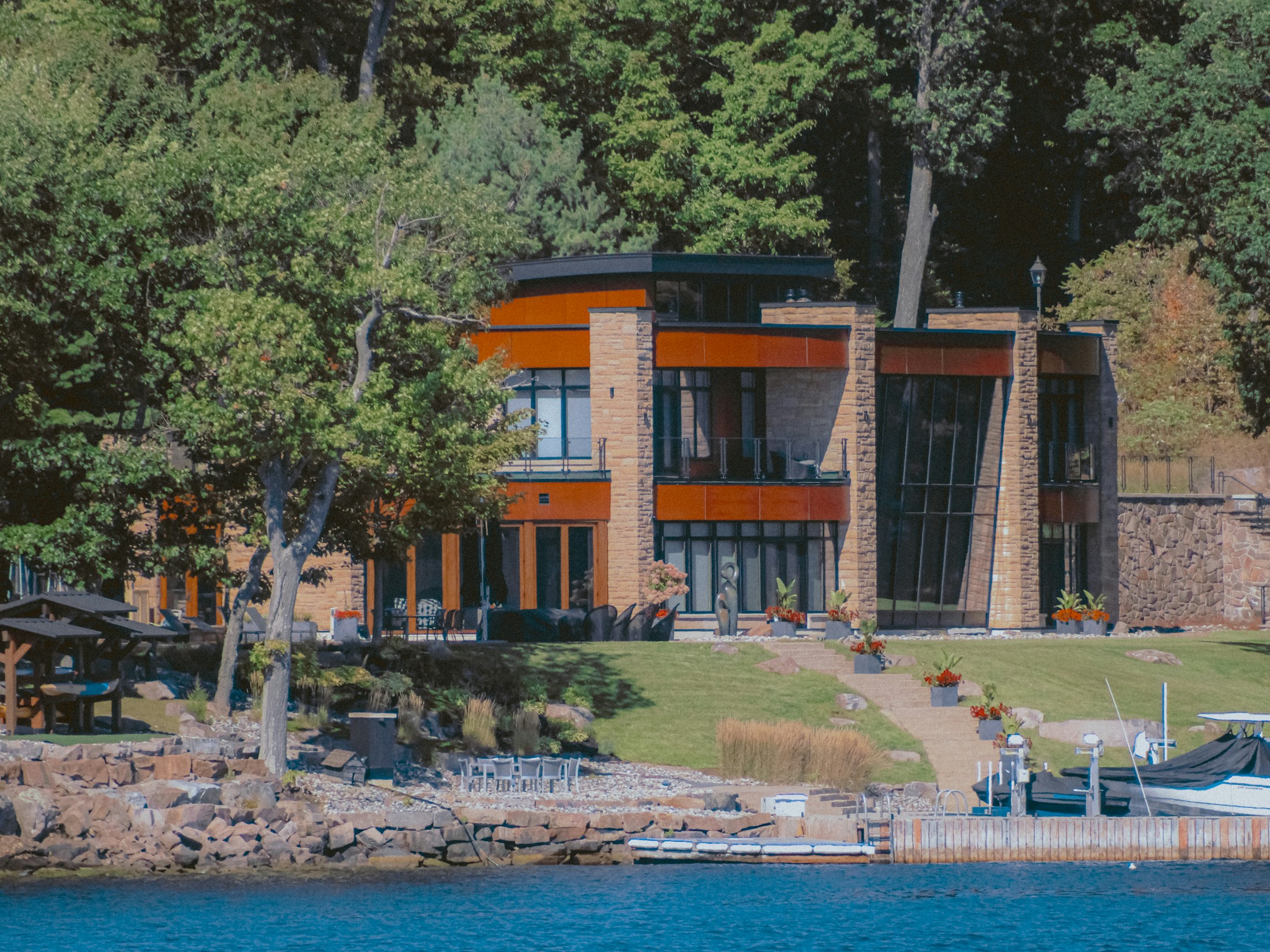 Contemporary waterfront home with tall windows and a lakeside lawn